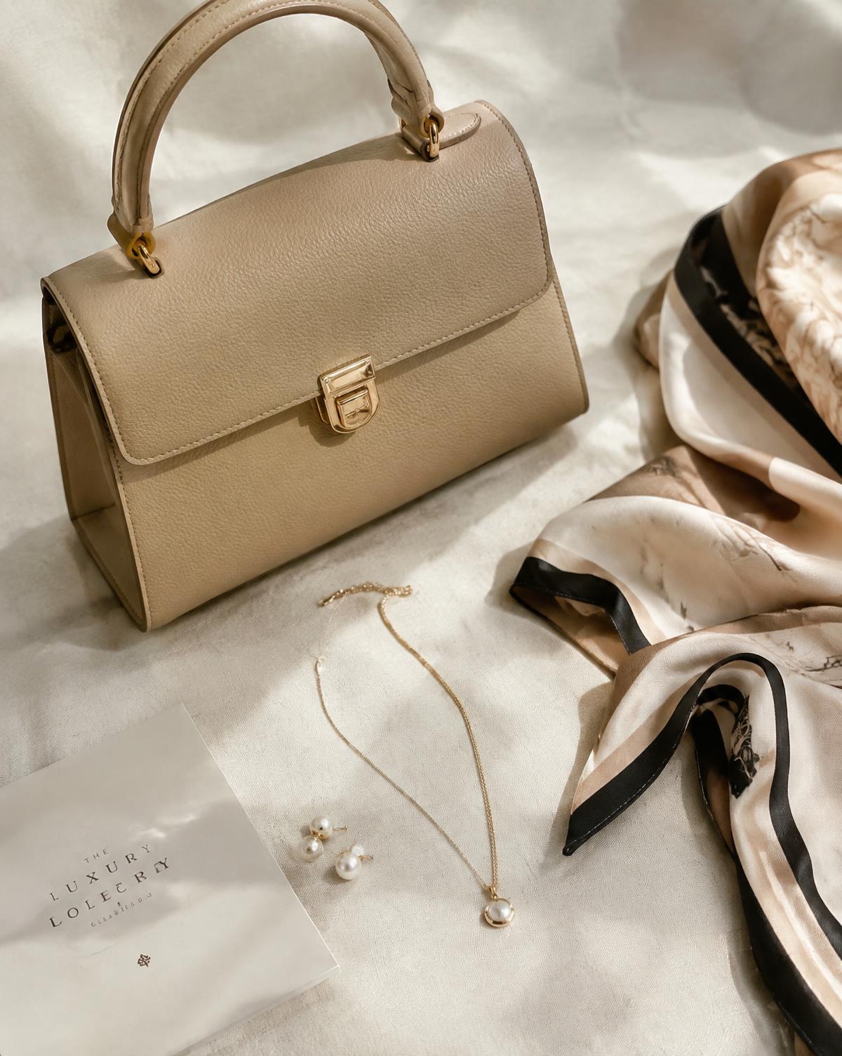 Handbag, pearls and silk scarf on linen